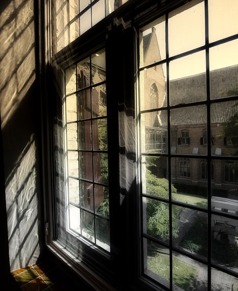 Foto van een raam in de kloostergang van Museum Catharijneconvent waar het licht mysterieus doorheen valt